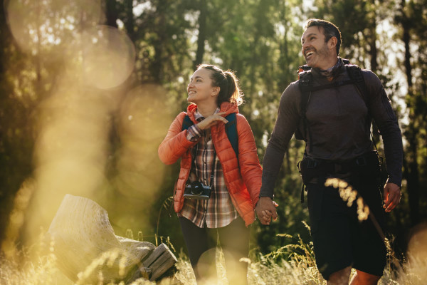 A young couple walking in nature smiling and happy.